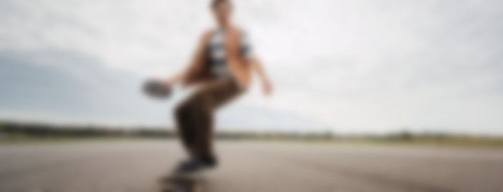 Mann auf Skateboard mit Rockster GO 2 in der Hand
